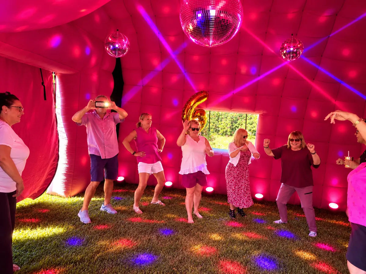 Guests dancing inside PopHaus with pink club lighting during a private party